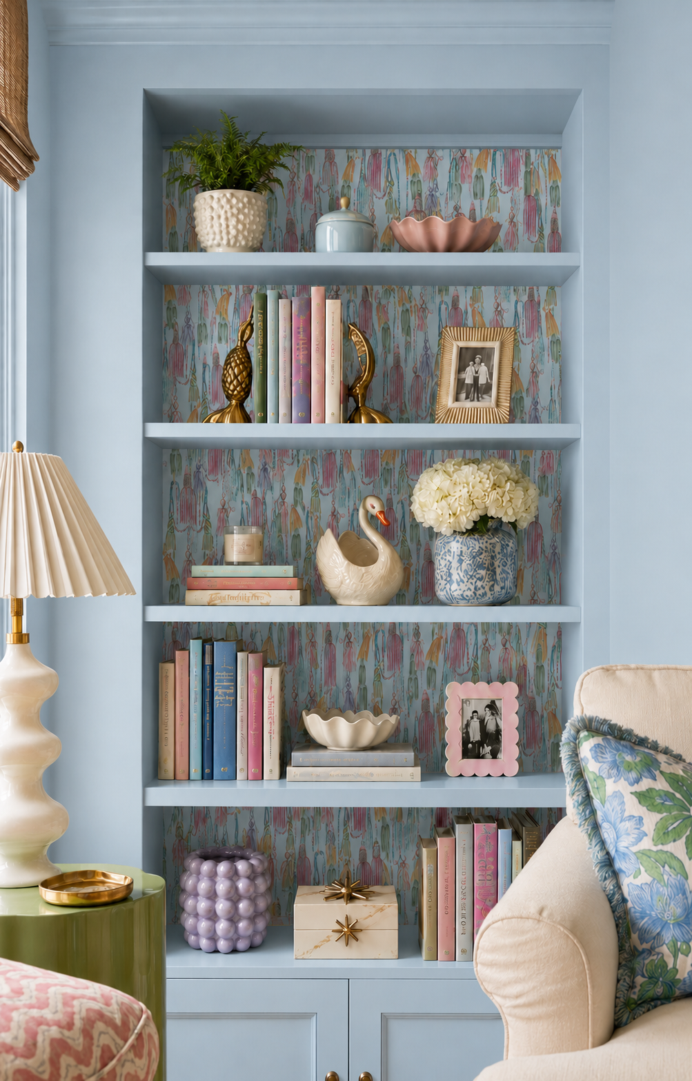 Patterned wallpaper installed behind a styled built-in bookshelf in a colorful living room