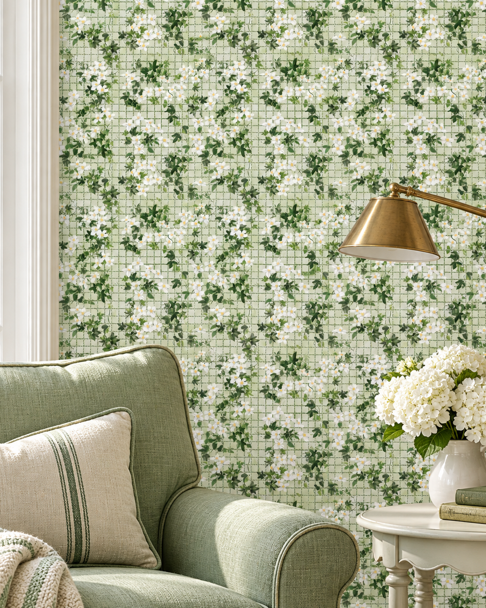 Green and white floral wallpaper with a grid pattern, shown in a styled living room setting behind a sage green armchair, a side table with white flowers, and a brass floor lamp.