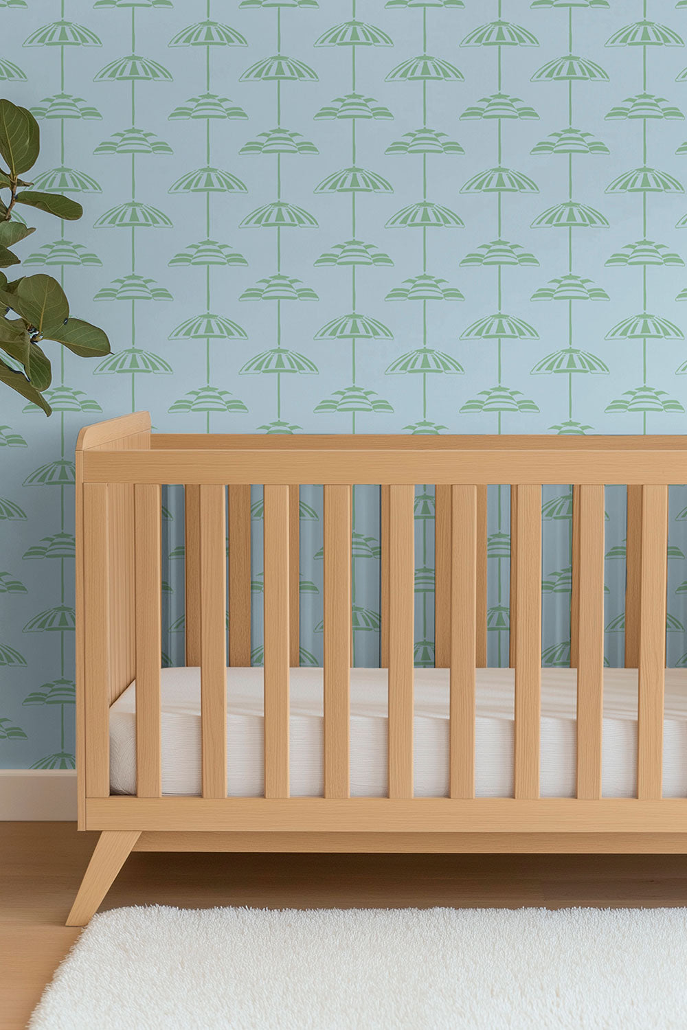 custom performance vinyl wallpaper that is washable and moisture repellant in calming beach soft ocean blue and light green beach umbrella stripes for interior designers and custom home builders of coastal beach homes, seen here in a gender neutral coastal inspired nursery