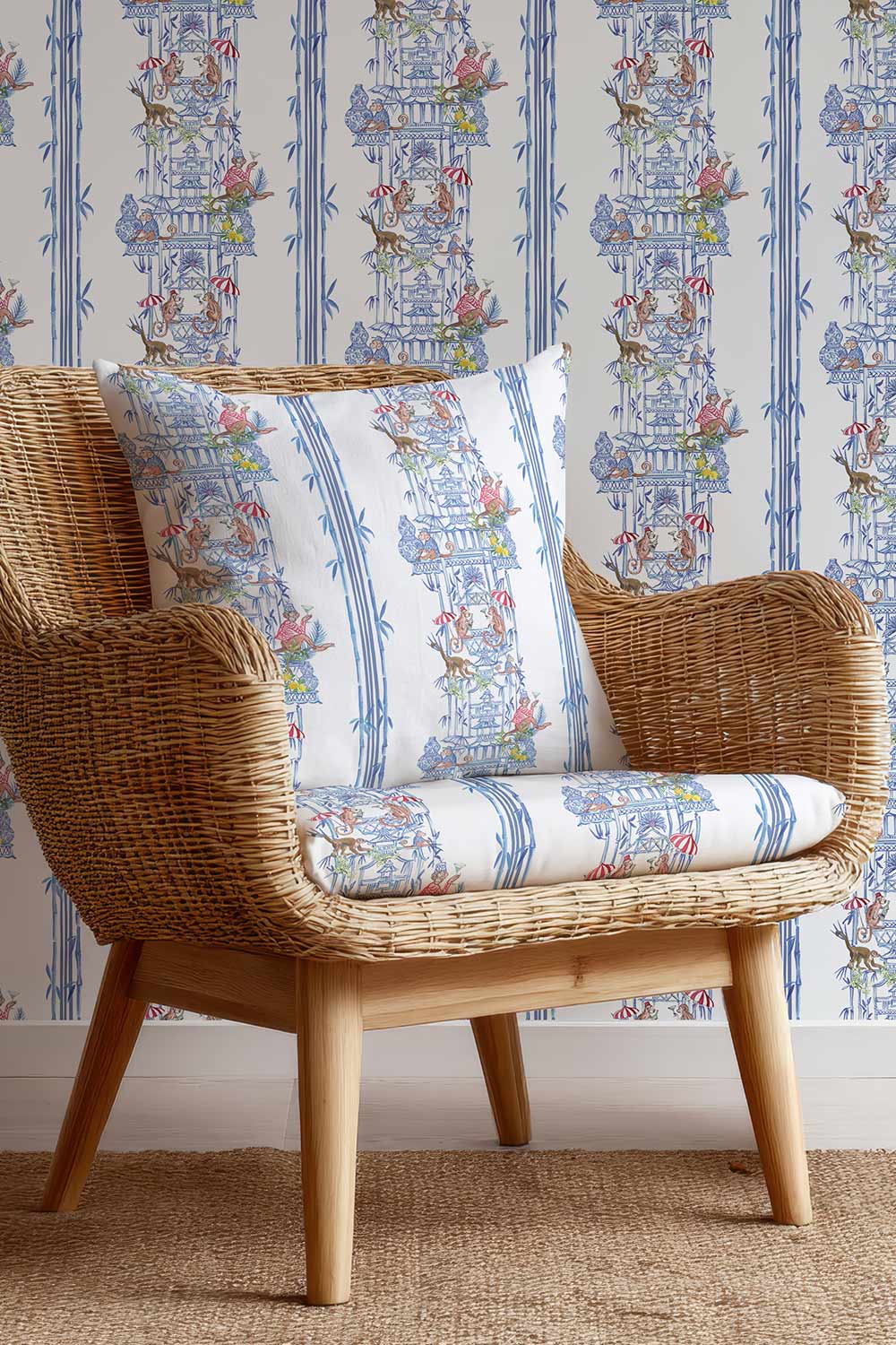 Whimsical chinoiserie toile upholstery fabric featuring pagodas, bamboo details, and monkeys partying in a hand-painted striped layout.