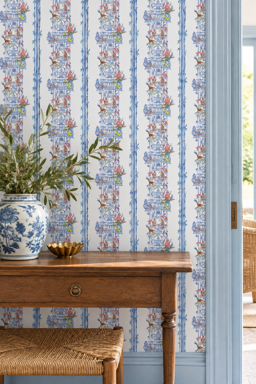 Hand-painted chinoiserie toile wallpaper featuring monkeys partying in pagodas, bamboo stripe details, and classic chintz-inspired motifs; shown in traditional blue colorways, perfect for entrances