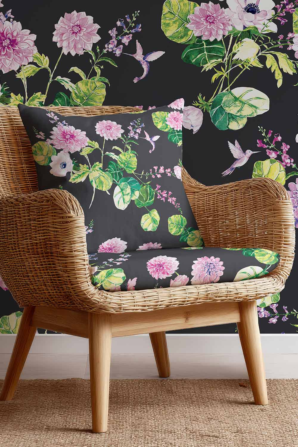 Botanical floral upholstery fabric with hand-painted dahlias, snapdragons, and hummingbirds in a vibrant, garden-inspired layout in a black base with pink and green flowers