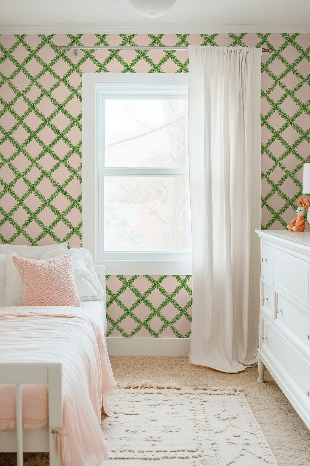 Ivy Trellis grasscloth wallpaper featuring hand-painted green leafy diamonds on a pastel pink woven natural fiber surface perfect for sweet little girl's bedrooms