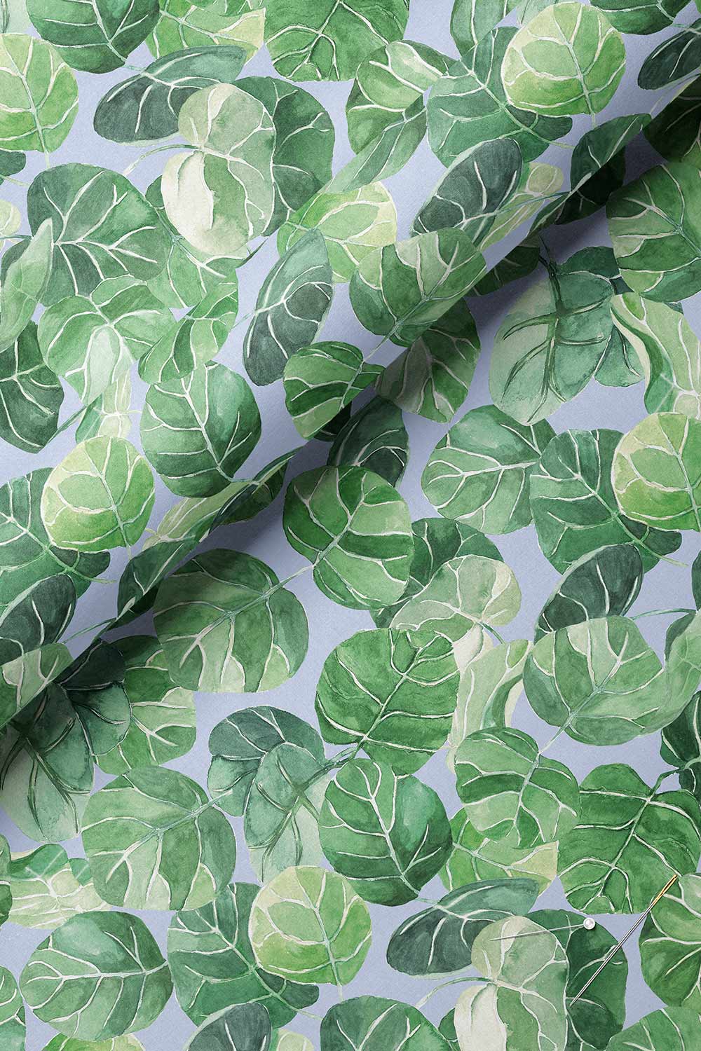 Tropical botanical upholstery fabric with large-scale hand-painted watercolor leaves in layered shades of green, inspired by coastal landscapes on light french blue ground color.