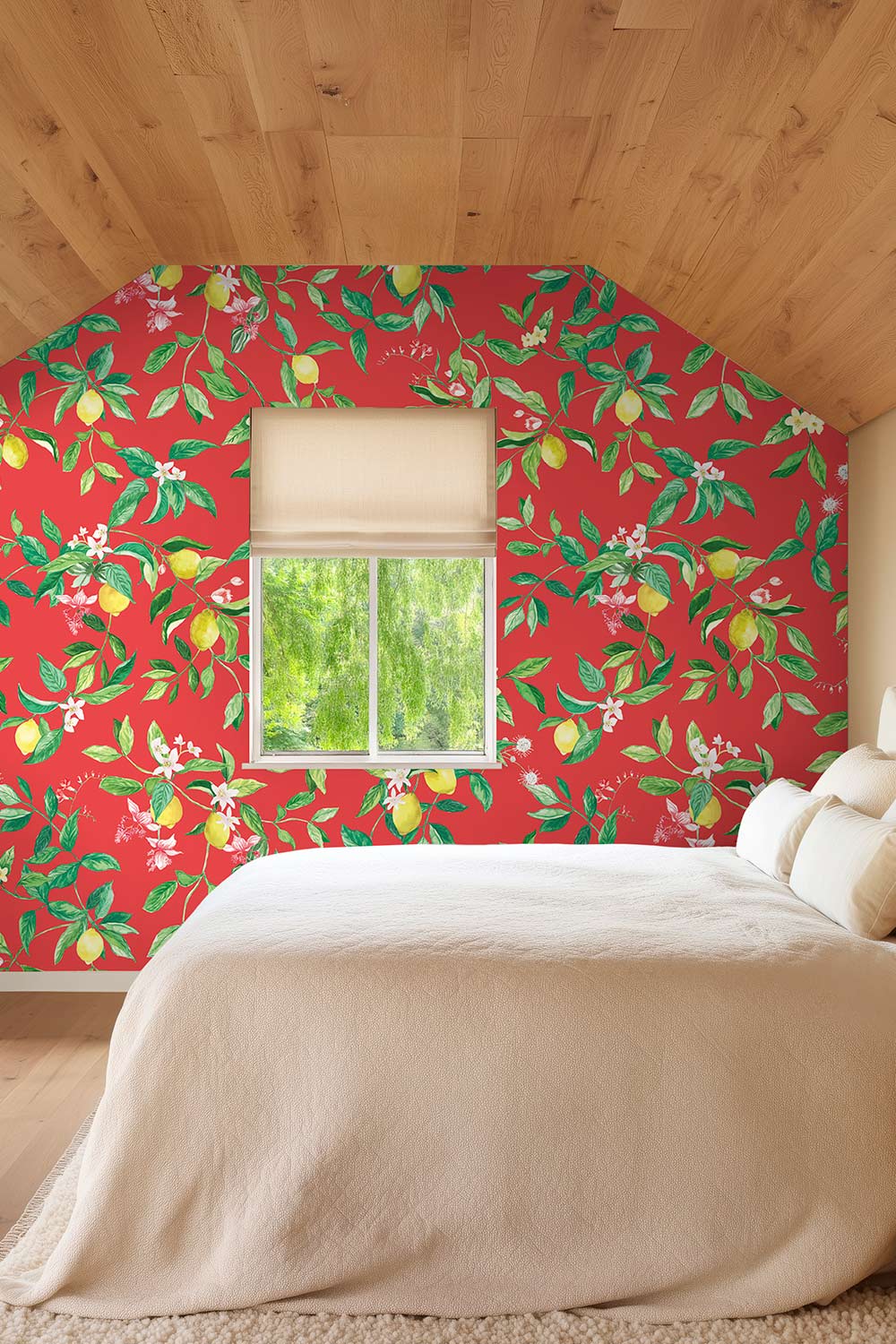 A bedroom scene with a bed dressed in cream bedding, set against a wall covered in bright red wallpaper with a green and yellow lemon and blossom print. A window above the bed shows greenery outside, and the room has a light wood slatted ceiling. lemon wallpaper, citrus wallpaper, limoncello wallpaper, blue wallpaper, fruit wallpaper, italian inspired wallpaper, kitchen wallpaper, lemon floral print on eco friendly traditional matte luxury wall covering