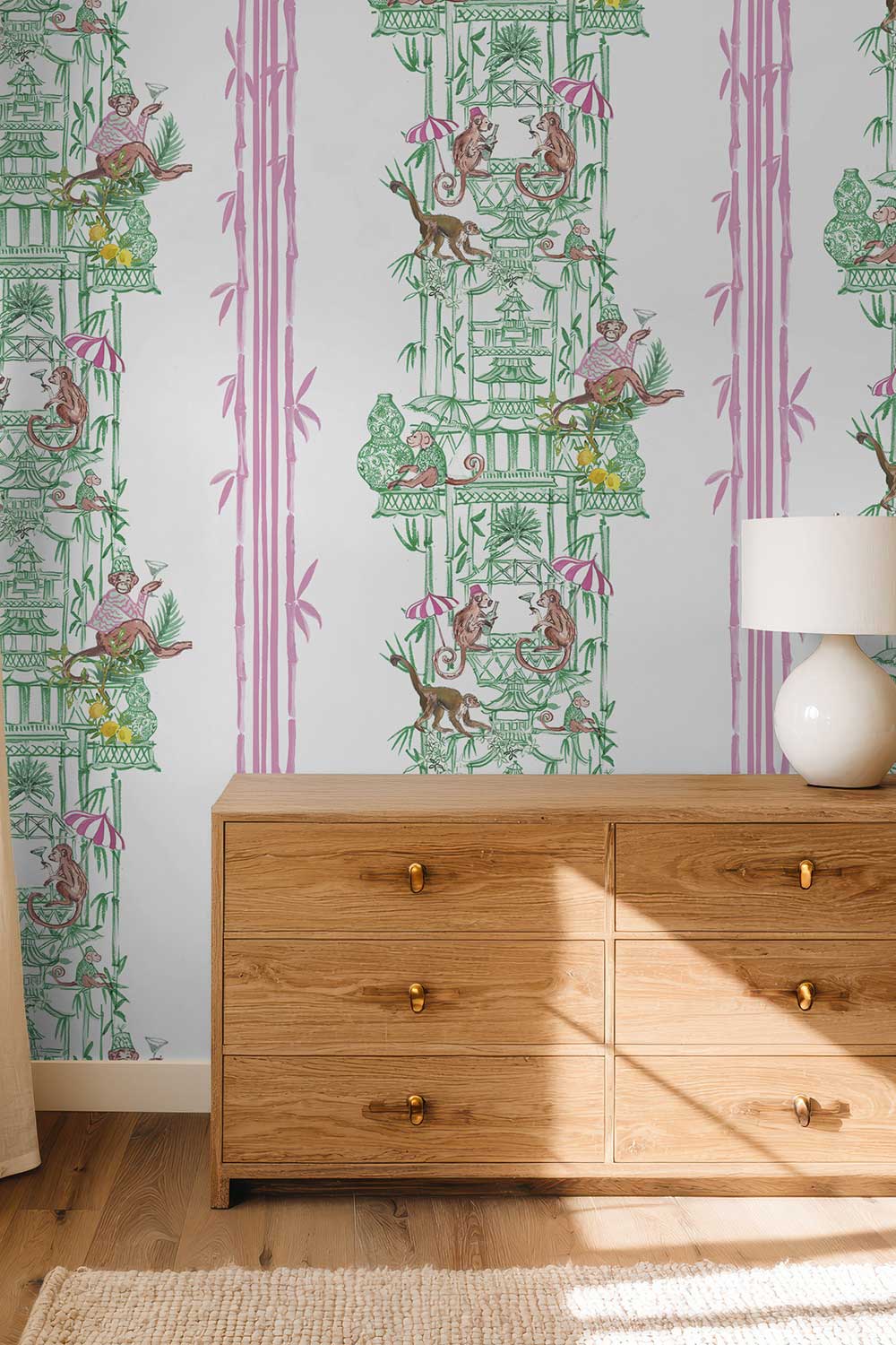 Chinoiserie Shenanigans removable peel and stick wallpaper in Bamboo Grove Green featuring playful monkeys, pagodas, porcelain vases and pink bamboo.