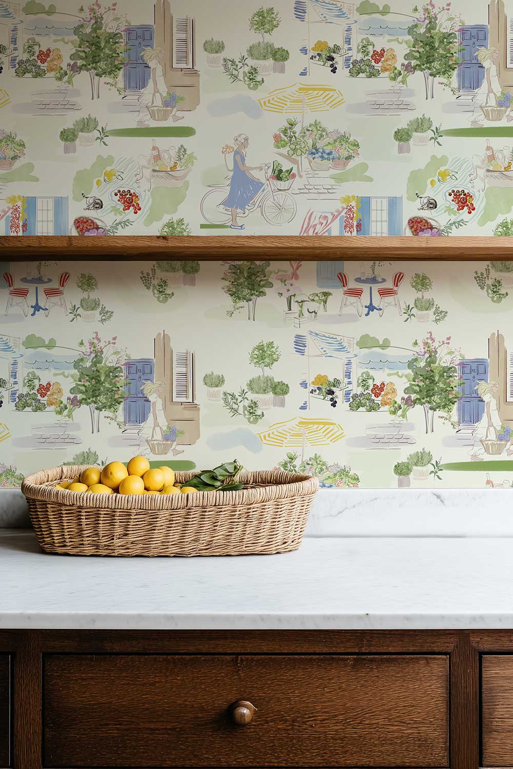 Farmer’s Market Toile peel and stick wallpaper in Morning Mint featuring a bicycle, flower stalls, fresh produce, potted herbs and a colorful French café featured in this country kitchen