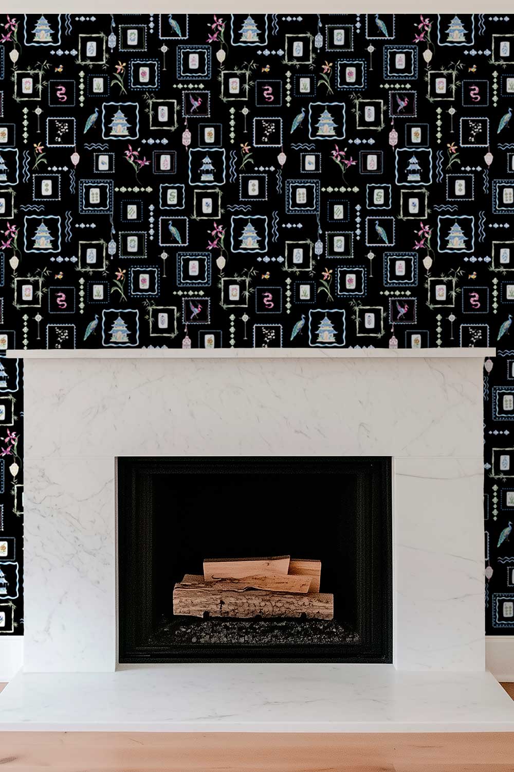 A fireplace with a white marble mantel and surround, set against a wall covered in black wallpaper with a white geometric and festive pattern. Hand-painted watercolor Mahjong Tiles wallpaper featuring mahjong tiles, pagodas, bamboo, birds, ginger jars, lanterns, and chinoiserie artwork on a rich black background printed on an all-natural and eco-friendly grasscloth wall-covering.