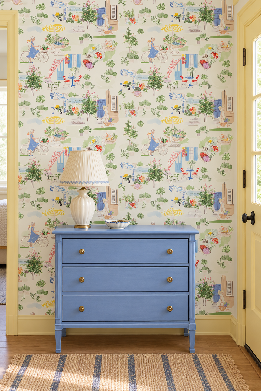 Farmer’s Market Toile peel and stick wallpaper in Morning Mint featuring a bicycle, flower stalls, fresh produce, potted herbs and a colorful French café featured in this foyer