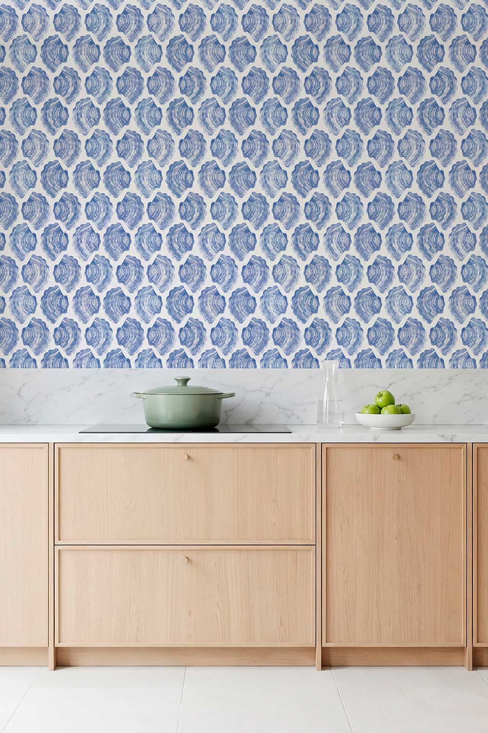 See Sells Sea Shells removable peel and stick wallpaper in Seaside Blue featuring rows of hand-painted blue and white watercolor oyster shells featured in this modern coastal kitchen