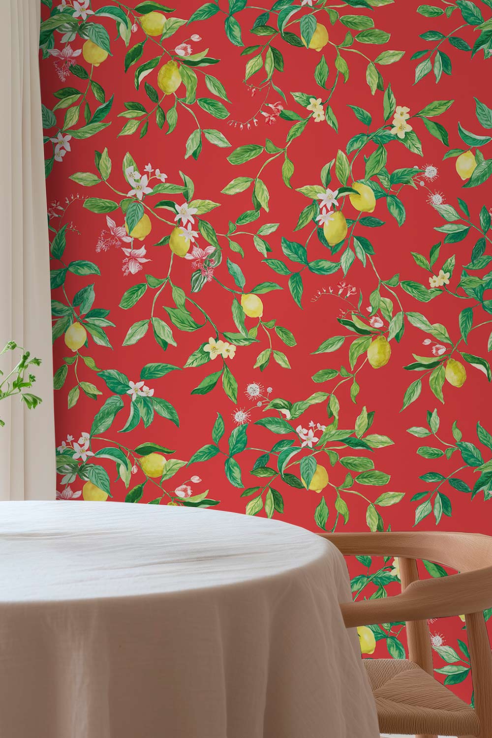 Red wallpaper with a green and yellow citrus fruit pattern, shown in a room setting behind a white tablecloth-covered round table and a wooden chair. lemon wallpaper, citrus wallpaper, limoncello wallpaper, blue wallpaper, fruit wallpaper, italian inspired wallpaper, kitchen wallpaper, lemon floral print on eco friendly traditional matte luxury wall covering