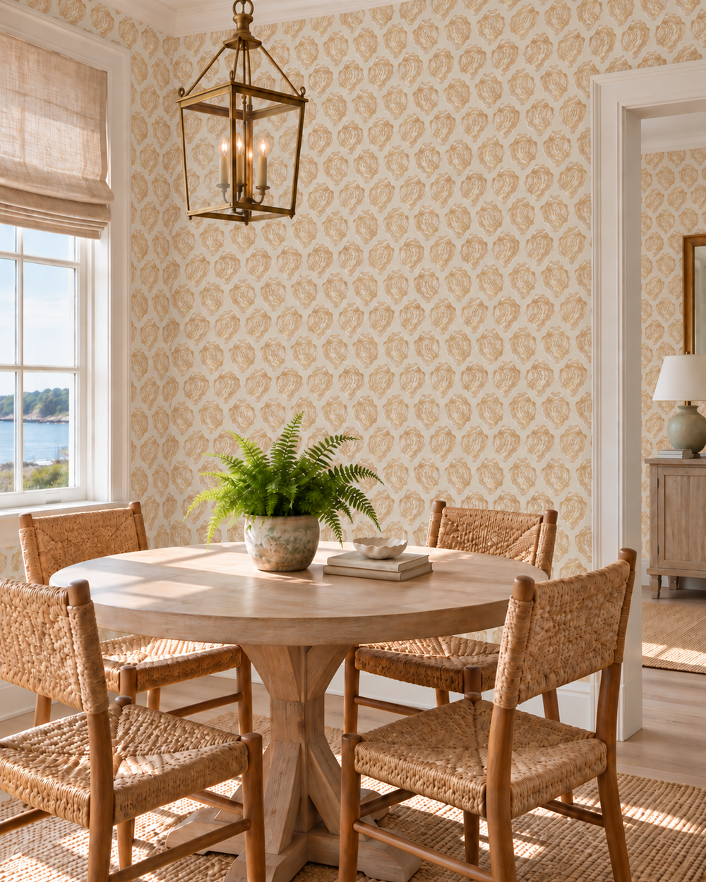 cozy coastal beach dining room with window seat, books on a shelf, and watercolor seashell striped wallpaper