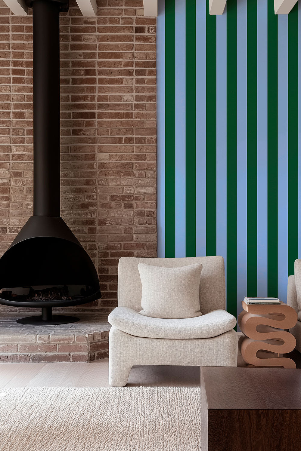 Modern living room with a white armchair, and brick fireplace with bold and unexpected narrow striped wallpaper