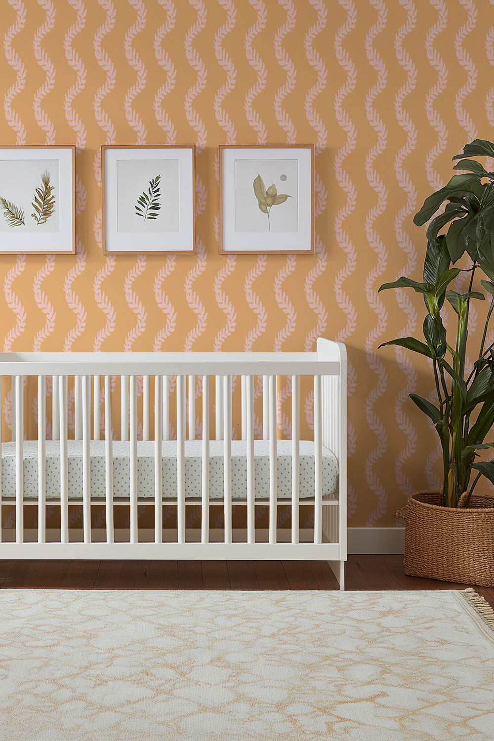 feminine baby girl nursery with garden leaf stripe in coral and pink wallpaper